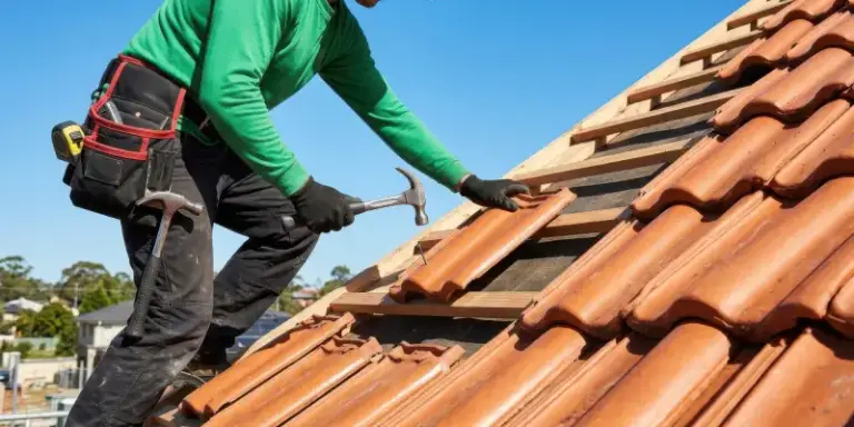 Couvreur posant des tuiles sur une toiture